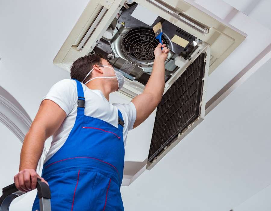 HVAC technician servicing a ceiling air handler